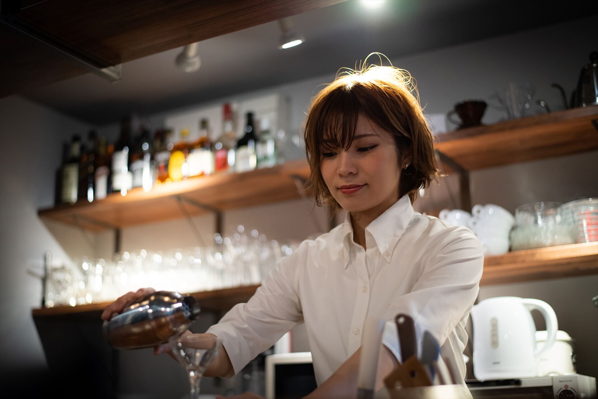 酒を注ぐ女性バーテンダー